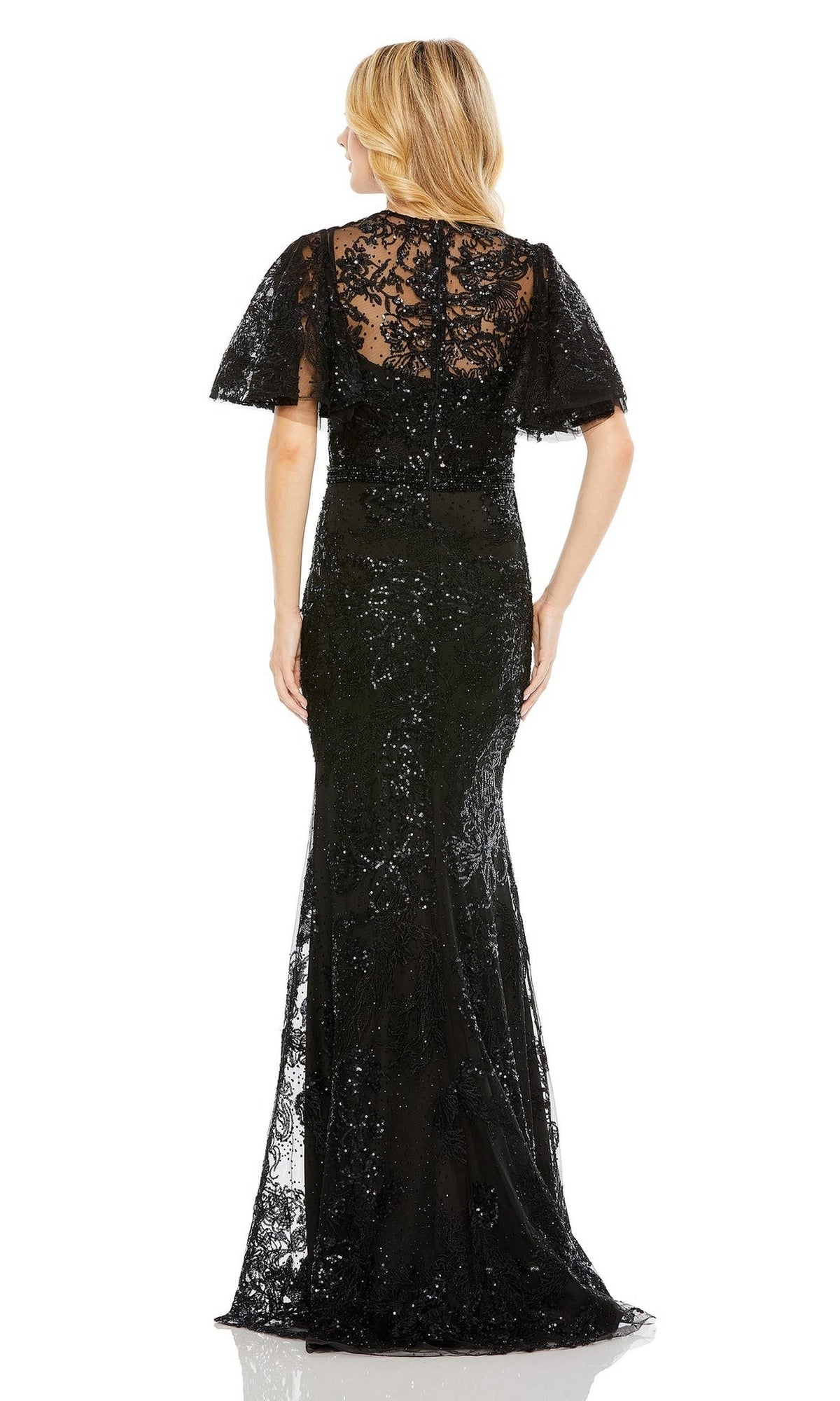 A woman faces away in a sparkly, black, floor-length, embroidered lace gown with short flutter sleeves—mirroring the elegance of the Mac Duggal 20438 Flutter-Sleeve Lace Formal Dress.